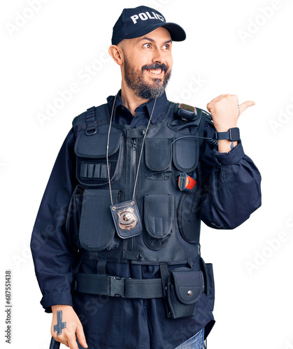 Young handsome man wearing police uniform smiling with happy face looking and pointing to the side with thumb up.