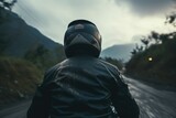 A man rides a motorcycle on a highway in the mountains.