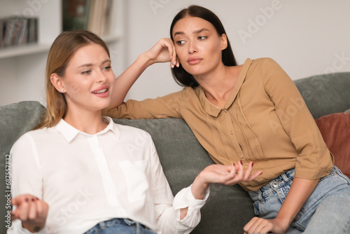 Tableau sur toile Jealous Woman Listening With Envy To Her Friend Bragging Indoors