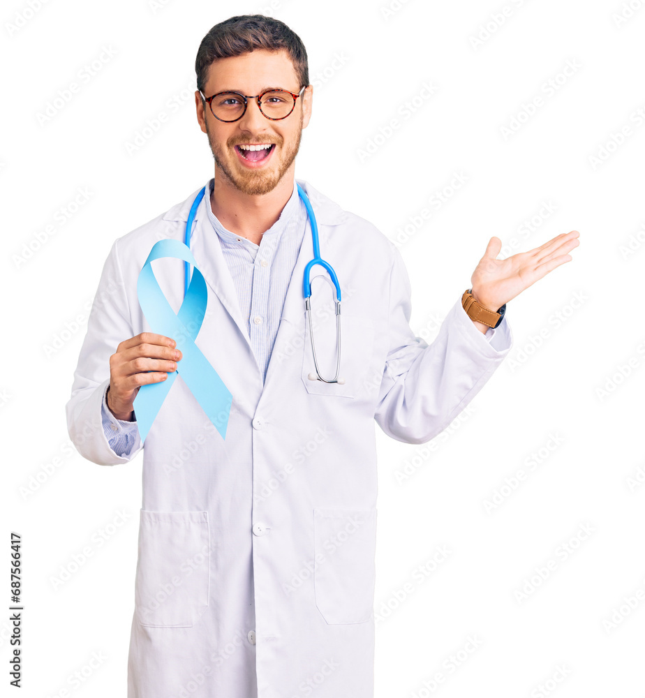 Handsome young man with bear wearing doctor uniform and holding blue ribbon celebrating victory with happy smile and winner expression with raised hands Handsome young man with bear wearing doctor uniform and holding blue ribbon celebrating victory with happy smile and winner expression with raised hands
