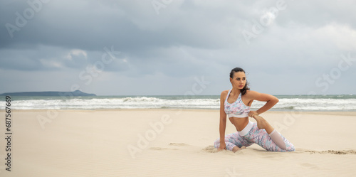 Wide panoramic shot of Young beautiful slender woman doing yoga on the sand beach.