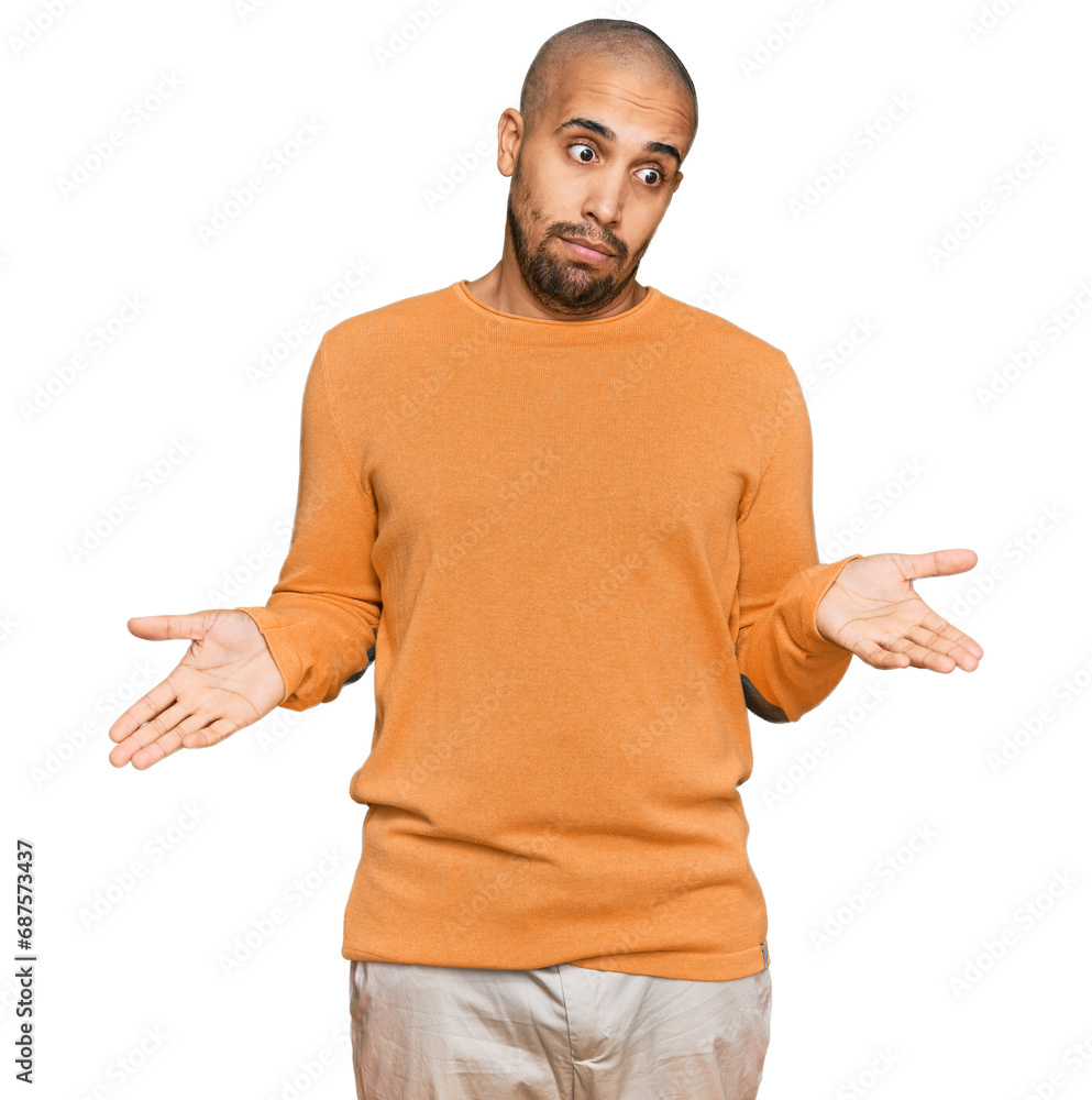 Hispanic adult man wearing casual winter sweater clueless and confused expression with arms and hands raised. doubt concept. Hispanic adult man wearing casual winter sweater clueless and confused expression with arms and hands raised. doubt concept.
