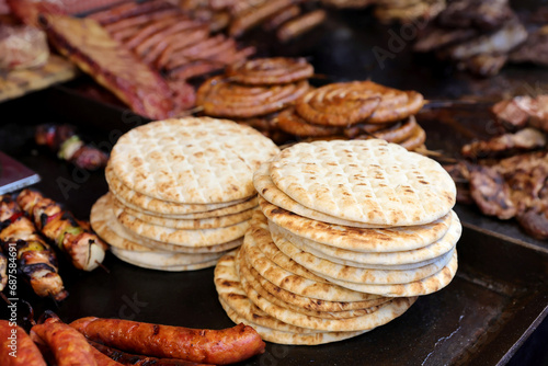 Pita bread nearby on grilled sousage and different tipe of meat on grill. photo