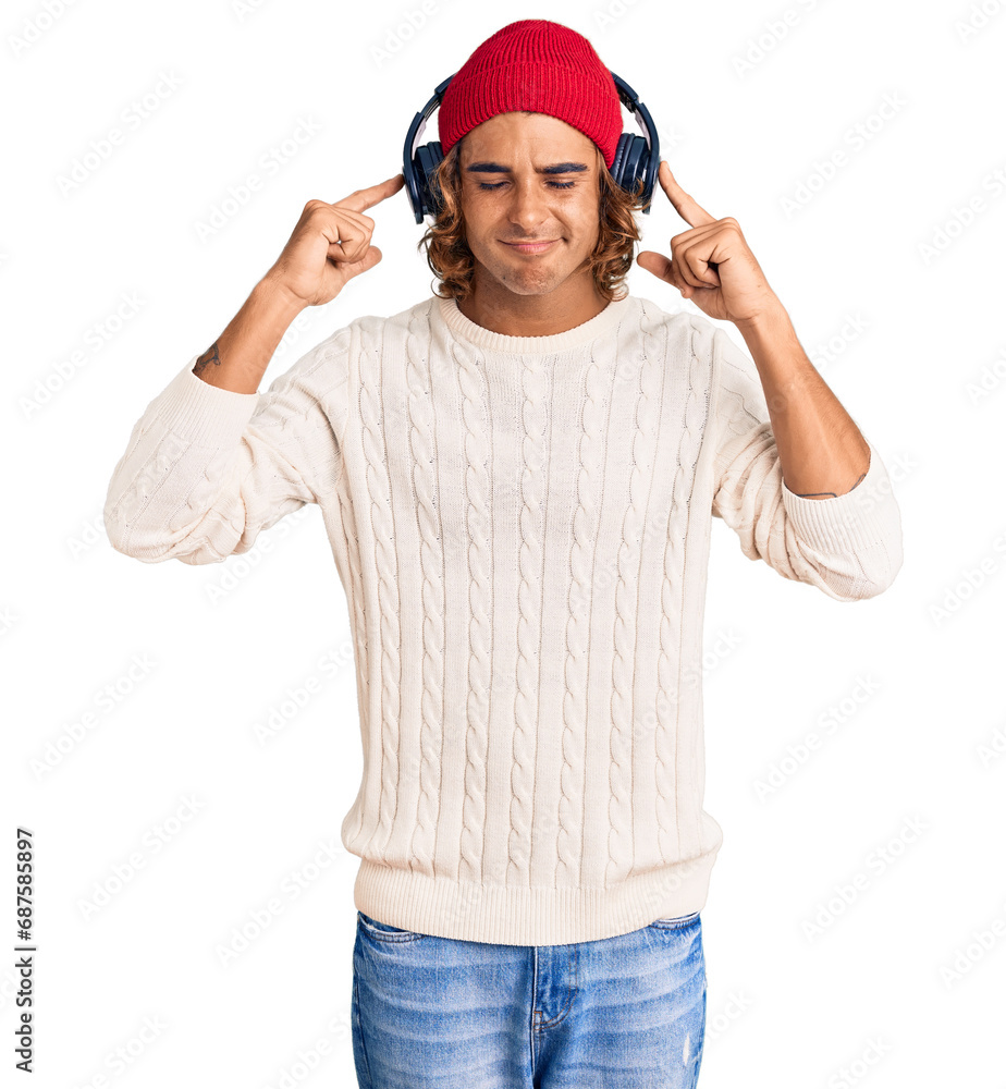 Φωτογραφία Young hispanic man listening to music using headphones covering ears with fingers with annoyed expression for the noise of loud music