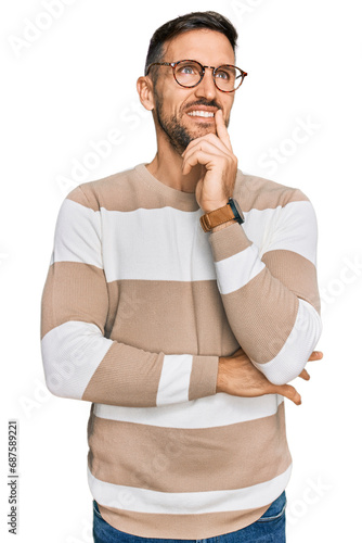 Handsome man with beard wearing casual clothes and glasses with hand on chin thinking about question, pensive expression. smiling and thoughtful face. doubt concept.