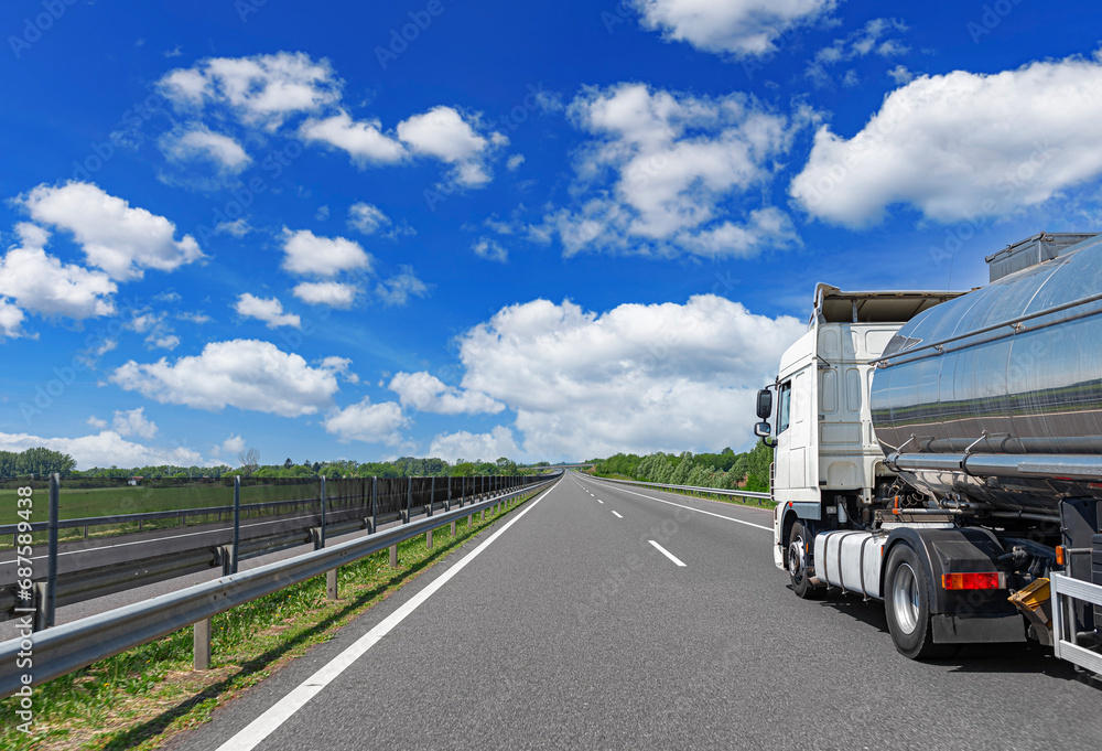 White truck on the highway. White truck on asphalt road. White truck on the highway. White truck on asphalt road.