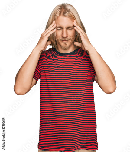 Caucasian man with blond long hair wearing casual striped t shirt with hand on head for pain in head because stress. suffering migraine.