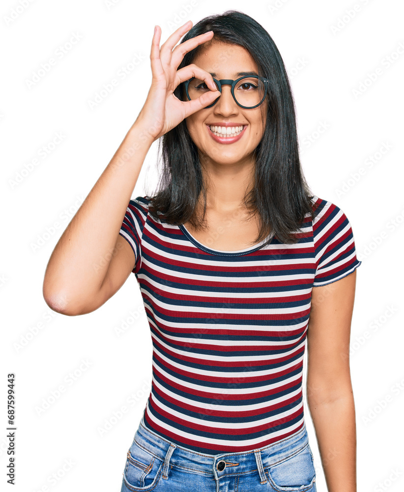 Beautiful asian young woman wearing casual clothes and glasses doing ok gesture with hand smiling, eye looking through fingers with happy face.