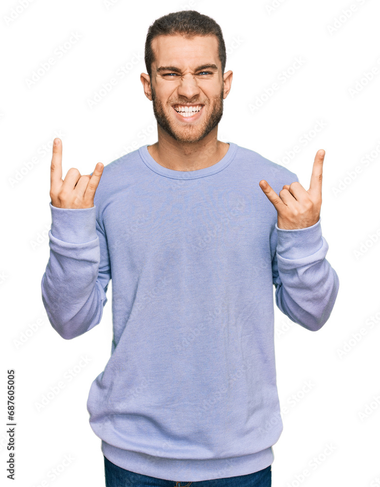 Fototapeta premium Young caucasian man wearing casual clothes shouting with crazy expression doing rock symbol with hands up. music star. heavy concept.