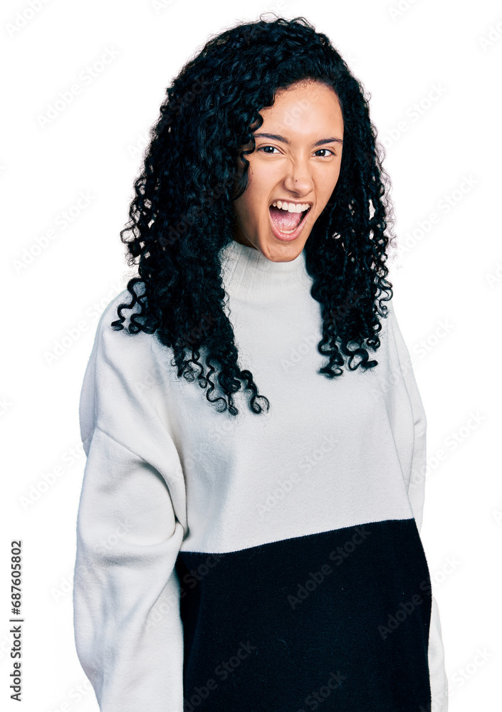 Young hispanic woman with curly hair wearing casual sweater winking looking at the camera with sexy expression, cheerful and happy face. Young hispanic woman with curly hair wearing casual sweater winking looking at the camera with sexy expression, cheerful and happy face.