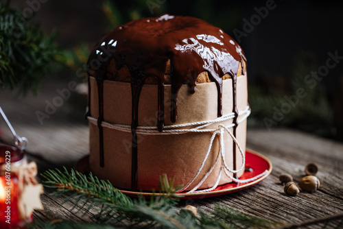 Christmas Panettone Cake with Melted Chocolate on Rustic Wooden Board and Festive Decorations - Holiday Dessert from Milan, Italy. 