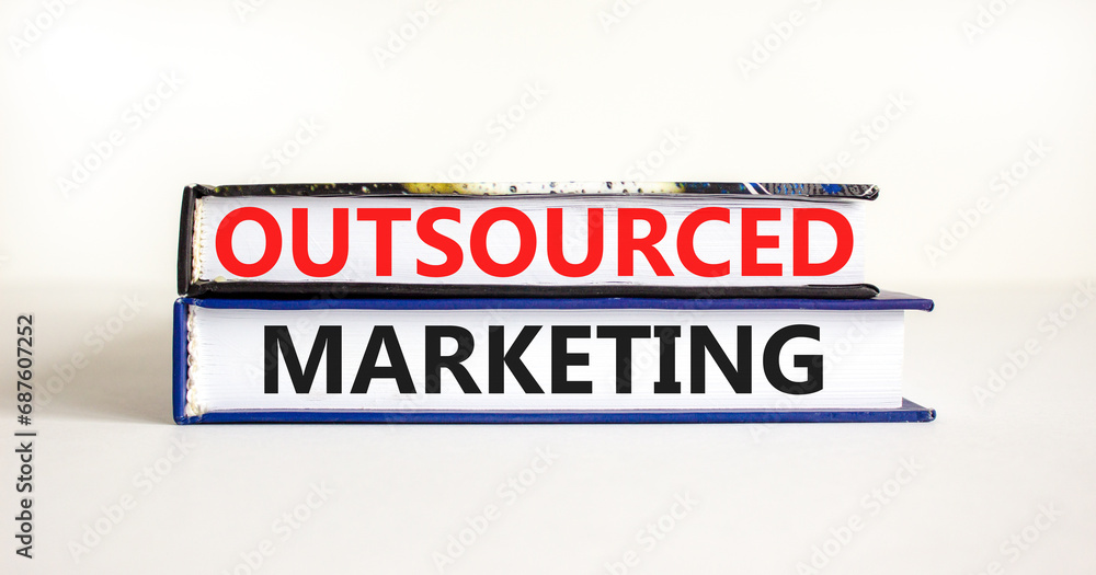 Outsourced marketing symbol. Concept words Outsourced marketing on beautiful books. Beautiful white table white background. Business Outsourced marketing concept. Copy space.