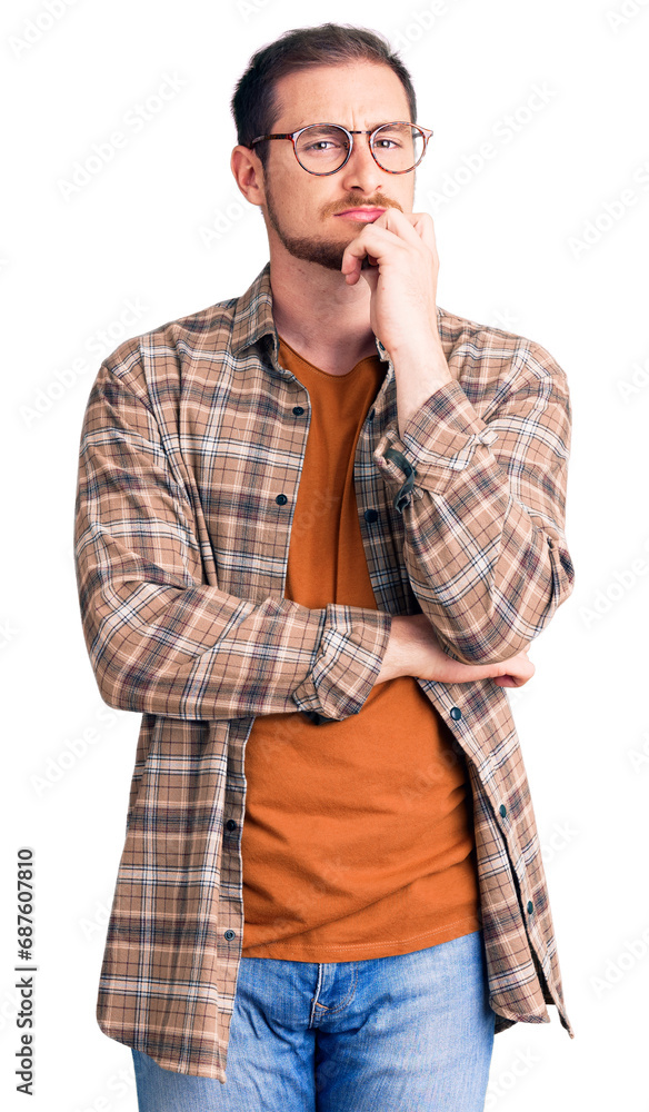 Young handsome caucasian man wearing casual clothes and glasses serious face thinking about question with hand on chin, thoughtful about confusing idea Young handsome caucasian man wearing casual clothes and glasses serious face thinking about question with hand on chin, thoughtful about confusing idea