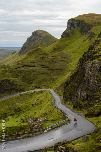 Fototapeta Naklejka Na Ścianę i Meble -  Cyclist pedaling up a windy road in the Trotternish Ridge on the Isle of Skye