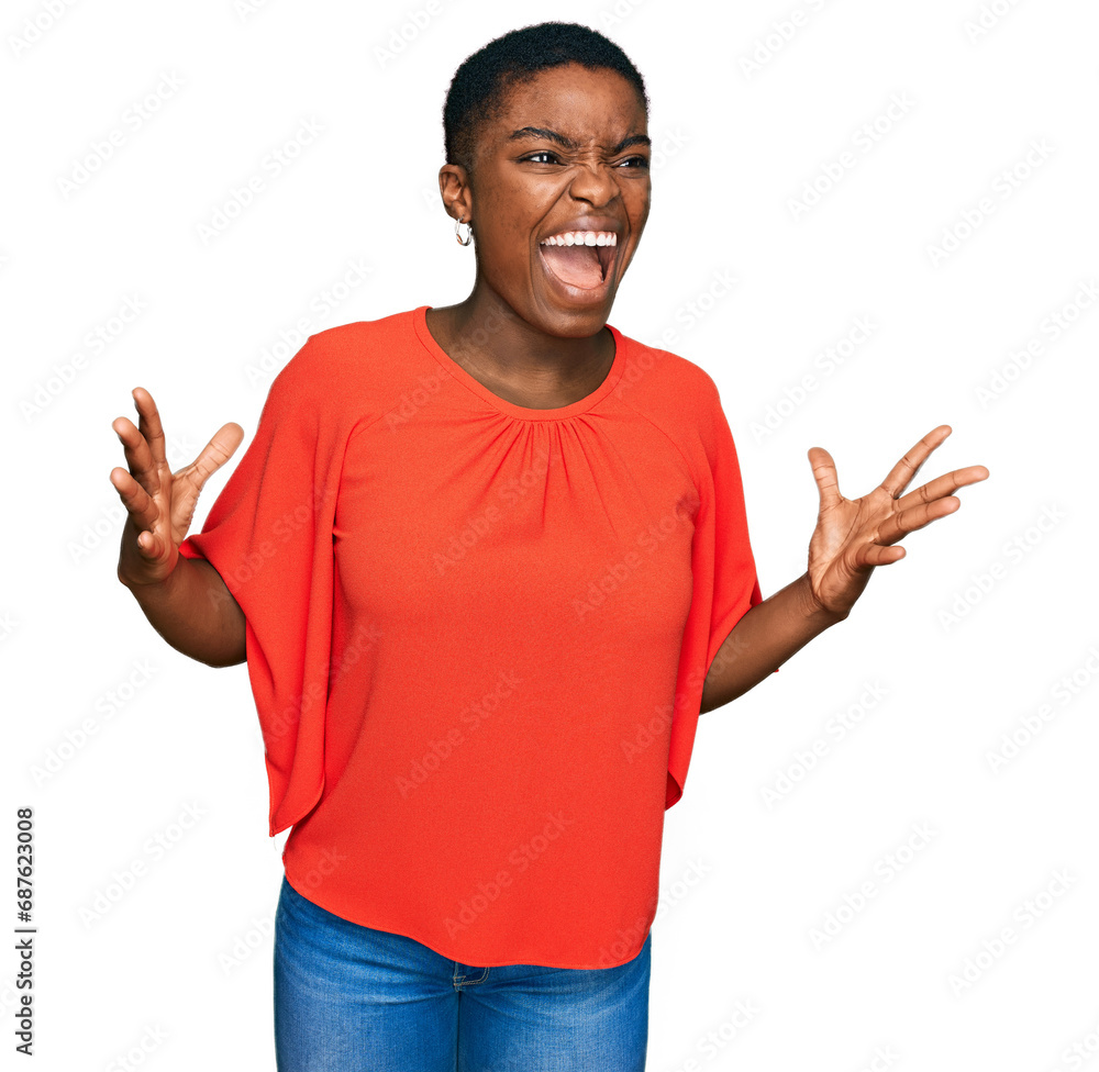 Young african american woman wearing casual clothes crazy and mad shouting and yelling with aggressive expression and arms raised. frustration concept. Young african american woman wearing casual clothes crazy and mad shouting and yelling with aggressive expression and arms raised. frustration concept.
