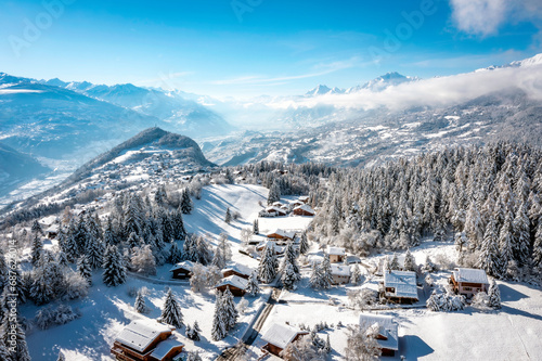 The Rhone valley in winter, in the Valais Alps, Switzerland from Crans-Montana ski resort with the villages of Lens, Icogne, Ayent and the town of Sion. photo