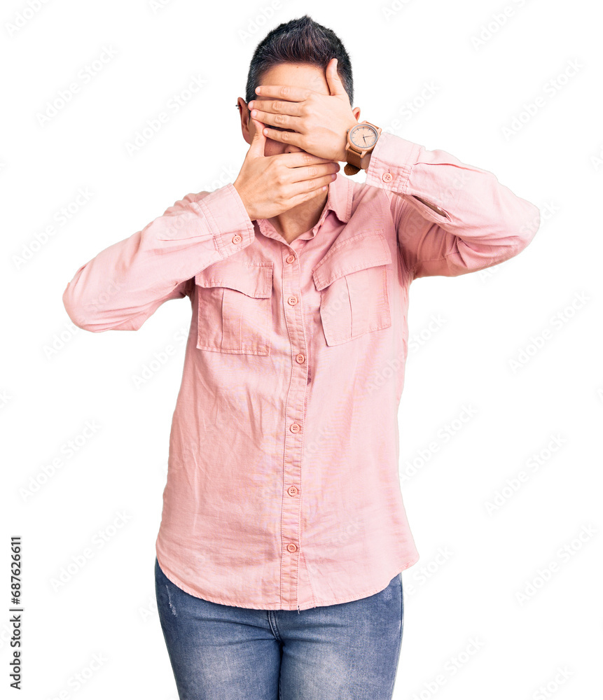 Young woman with short hair wearing casual clothes covering eyes and mouth with hands, surprised and shocked. hiding emotion Young woman with short hair wearing casual clothes covering eyes and mouth with hands, surprised and shocked. hiding emotion