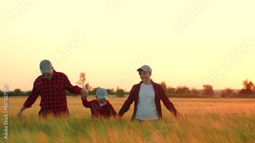 Mom dad child boy run  walk hand in hand. Slow motion. Happy family of farmers with child  are walking run on wheat field. Happy mother  father and little son enjoying nature together  outdoor  sun