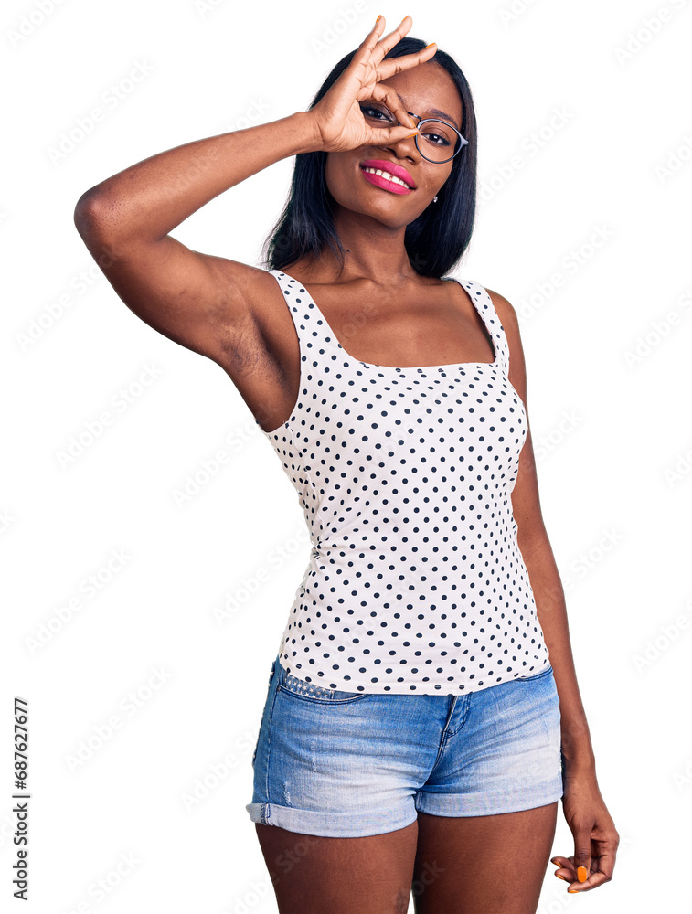 Young african american woman wearing casual clothes and glasses smiling happy doing ok sign with hand on eye looking through fingers Young african american woman wearing casual clothes and glasses smiling happy doing ok sign with hand on eye looking through fingers