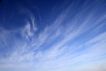 Beautiful blue sky with white wispy clouds, a perfect replacement background for photos.