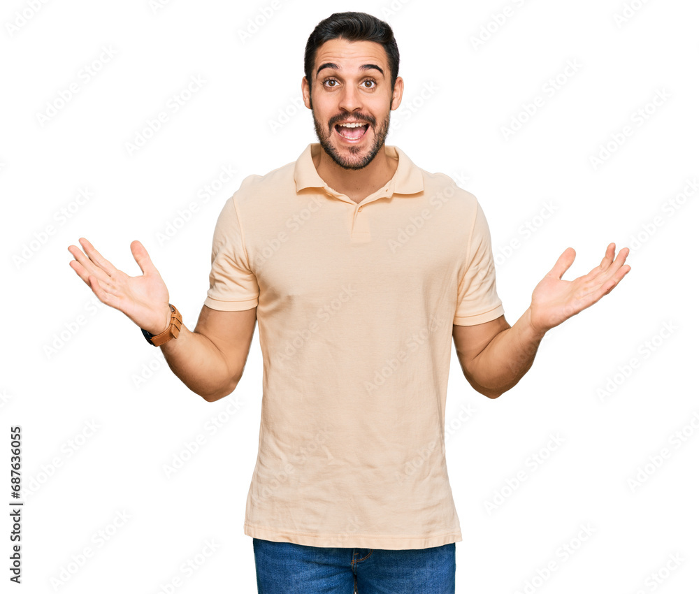Young hispanic man wearing casual clothes celebrating victory with happy smile and winner expression with raised hands Young hispanic man wearing casual clothes celebrating victory with happy smile and winner expression with raised hands