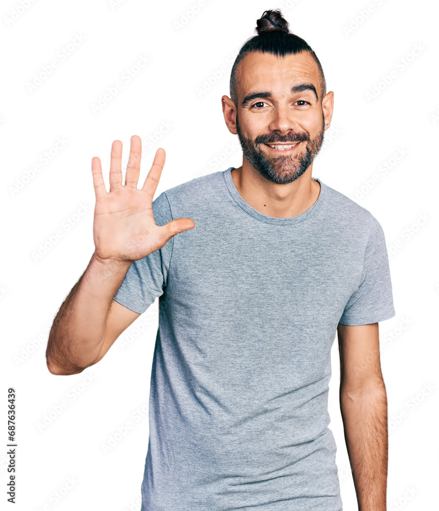 Hispanic man with ponytail wearing casual grey t shirt showing and pointing up with fingers number five while smiling confident and happy. Hispanic man with ponytail wearing casual grey t shirt showing and pointing up with fingers number five while smiling confident and happy.