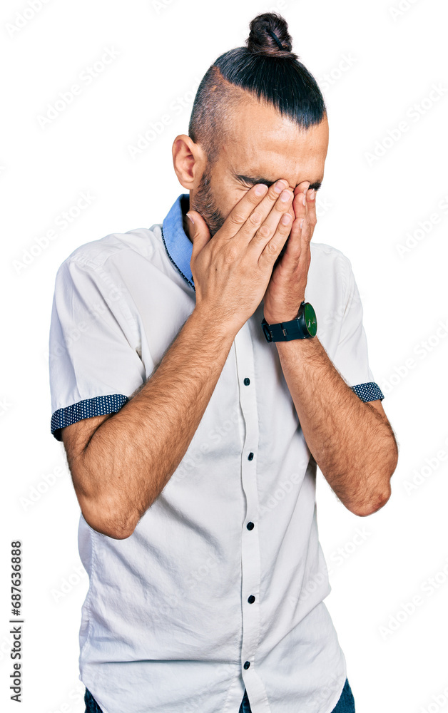 Hispanic man with ponytail wearing casual white shirt rubbing eyes for fatigue and headache, sleepy and tired expression. vision problem Hispanic man with ponytail wearing casual white shirt rubbing eyes for fatigue and headache, sleepy and tired expression. vision problem