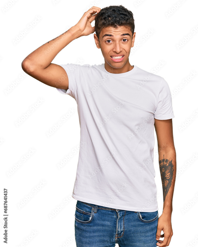 Young handsome african american man wearing casual white tshirt confuse and wonder about question. uncertain with doubt, thinking with hand on head. pensive concept. Young handsome african american man wearing casual white tshirt confuse and wonder about question. uncertain with doubt, thinking with hand on head. pensive concept.