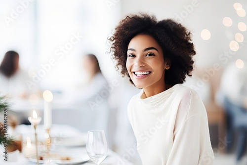 Portrait of a happy and cheerful black lady in a restaurant during Christmas.