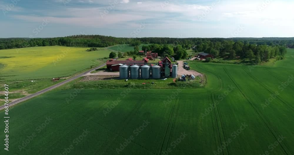 Aerial Shot Of Silos Outside Small Factory On Green Landscape While Drone Flying Backwards During Sunny Day - Mariefred, Sweden Aerial Shot Of Silos Outside Small Factory On Green Landscape While Drone Flying Backwards During Sunny Day - Mariefred, Sweden
