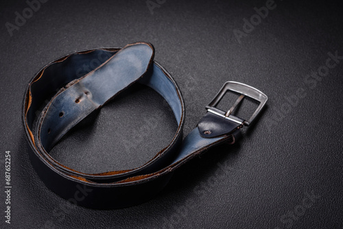 Old leather men's belt with an old-style metal buckle photo