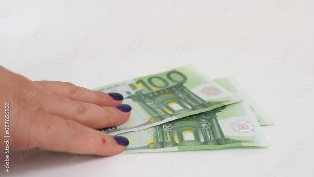 Female hands, Euro counting. Depicting finance and accounting themes. A person is counting 100 Euro bills on a white table. Female hands, Euro counting. Depicting finance and accounting themes. A person is counting 100 Euro bills on a white table.