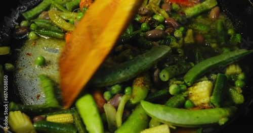 Green asol vegetables with onions and carrots and peas in sauce and spices are fried with a crust in a frying pan. Medium plan. photo