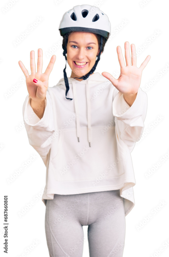 Beautiful brunette young woman wearing bike helmet and sporty clothes showing and pointing up with fingers number nine while smiling confident and happy. Beautiful brunette young woman wearing bike helmet and sporty clothes showing and pointing up with fingers number nine while smiling confident and happy.