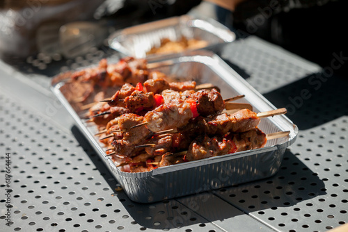 fried grilled meat on wooden skewers