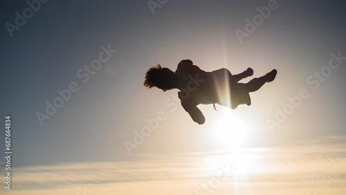 silhouette of a guy doing backflip in sunset