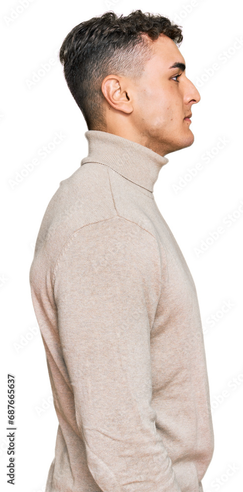 Hispanic young man wearing casual turtleneck sweater looking to side, relax profile pose with natural face with confident smile. Hispanic young man wearing casual turtleneck sweater looking to side, relax profile pose with natural face with confident smile.