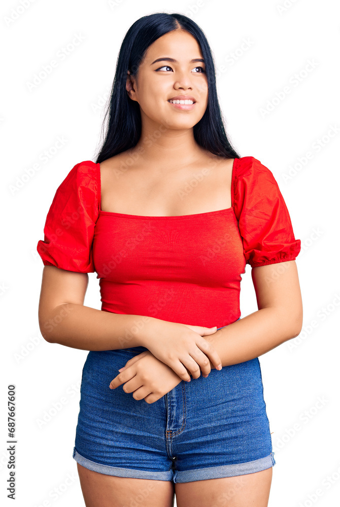 Fototapeta premium Young beautiful asian girl wearing casual clothes looking away to side with smile on face, natural expression. laughing confident.