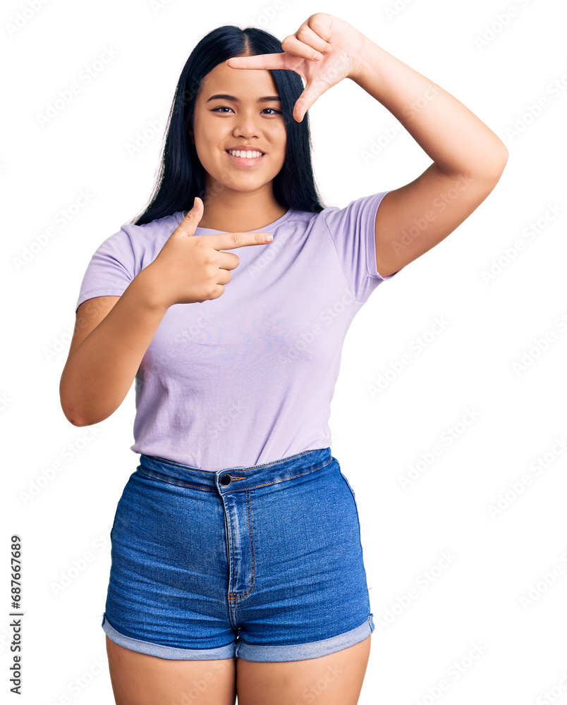 Obraz premium Young beautiful asian girl wearing casual clothes smiling making frame with hands and fingers with happy face. creativity and photography concept.