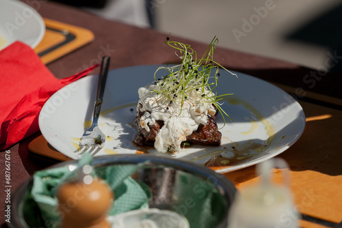 juicy steak on a plate with sauce and microgreens