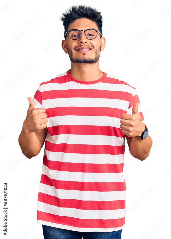 Handsome latin american young man wearing casual clothes and glasses success sign doing positive gesture with hand, thumbs up smiling and happy. cheerful expression and winner gesture. Handsome latin american young man wearing casual clothes and glasses success sign doing positive gesture with hand, thumbs up smiling and happy. cheerful expression and winner gesture.