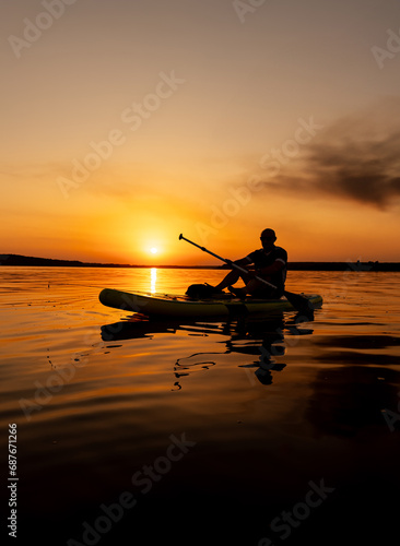 A Tranquil Kayaking Adventure at Sunset. A person in a kayak on a body of water at sunset