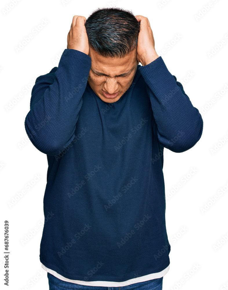 Naklejka premium Young latin man wearing casual clothes suffering from headache desperate and stressed because pain and migraine. hands on head.