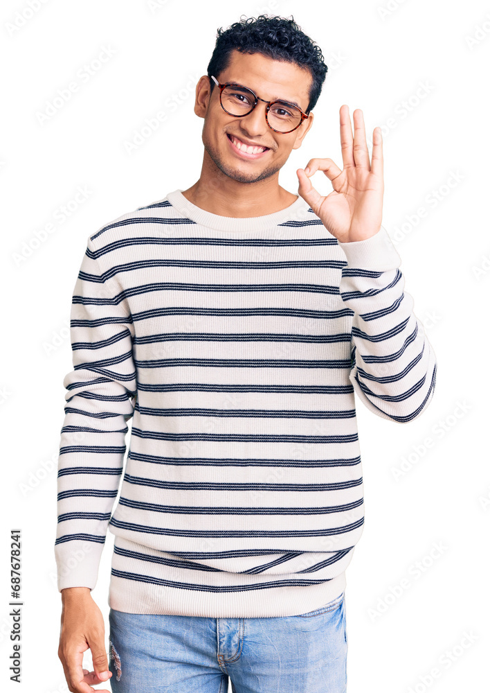 Fototapeta premium Hispanic handsome young man wearing casual clothes and glasses smiling positive doing ok sign with hand and fingers. successful expression.