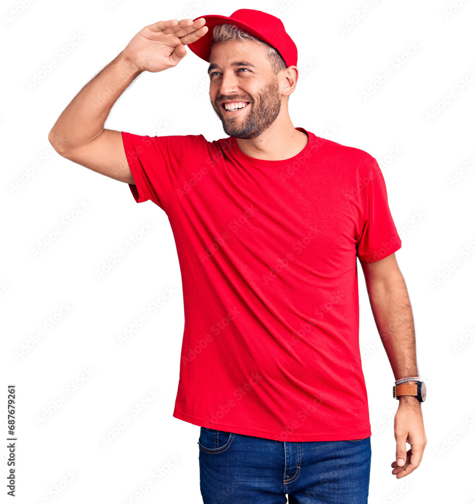 Young handsome blond man wearing t-shirt and cap very happy and smiling looking far away with hand over head. searching concept. Young handsome blond man wearing t-shirt and cap very happy and smiling looking far away with hand over head. searching concept.