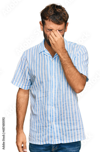 Handsome young man with beard wearing casual fresh shirt tired rubbing nose and eyes feeling fatigue and headache. stress and frustration concept.