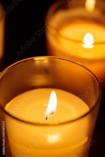 Aromatic Candles in Glass: Warm Glow on Dark Background, Close-up