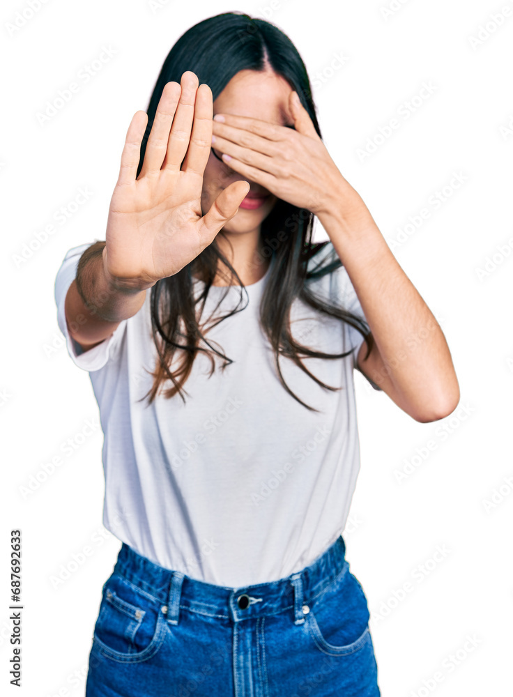 Young hispanic woman wearing casual clothes and glasses covering eyes with hands and doing stop gesture with sad and fear expression. embarrassed and negative concept. Young hispanic woman wearing casual clothes and glasses covering eyes with hands and doing stop gesture with sad and fear expression. embarrassed and negative concept.