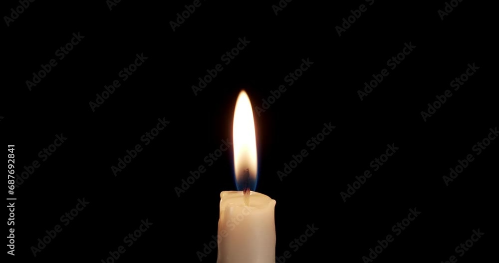 A single white candle burning.Isolated candle burning with dark background.White paraffin candle with yellow shades burns on a black background.Background or illustration of remembrance or celebration A single white candle burning.Isolated candle burning with dark background.White paraffin candle with yellow shades burns on a black background.Background or illustration of remembrance or celebration