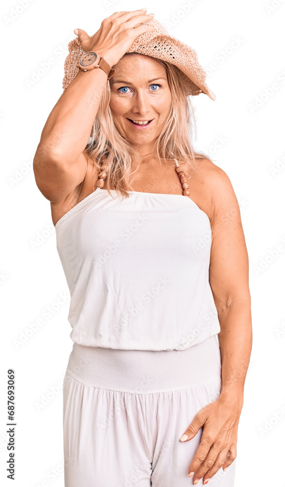 Middle age fit blonde woman wearing summer hat surprised with hand on head for mistake, remember error. forgot, bad memory concept. Middle age fit blonde woman wearing summer hat surprised with hand on head for mistake, remember error. forgot, bad memory concept.